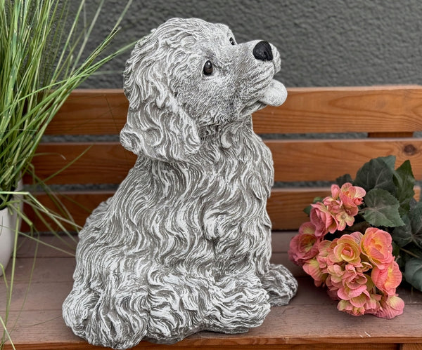 Seitenansicht Steinfigur Hund Welpe – detailreiche Lockenfell-Textur, sitzender Welpe mit Zunge, wetterfeste  handgefertigte Hundestatue aus Steinguss