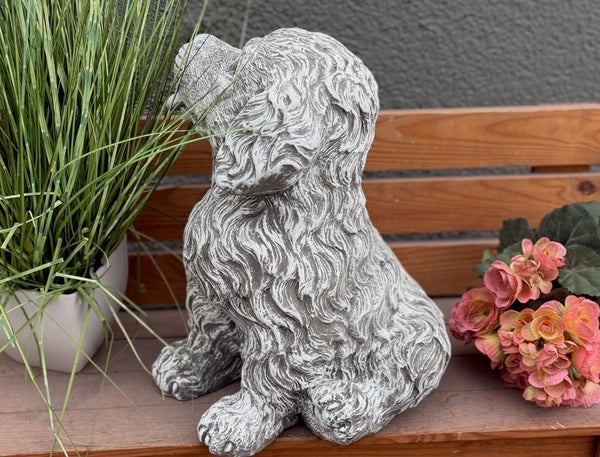 Seitenansicht Steinfigur Hund Welpe – detailreiche Lockenfell-Textur, sitzender Welpe mit Zunge, wetterfeste  handgefertigte Hundestatue aus Steinguss