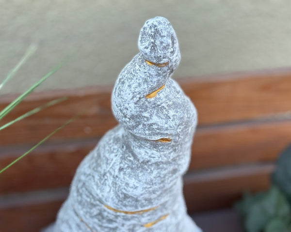 Detail gedrehte Zipfelmütze Steinfigur Wichtel – spiralförmige graue Mütze mit goldenen/orangen Linien, frostfeste handgefertigte Gnom-Figur aus Steinguss