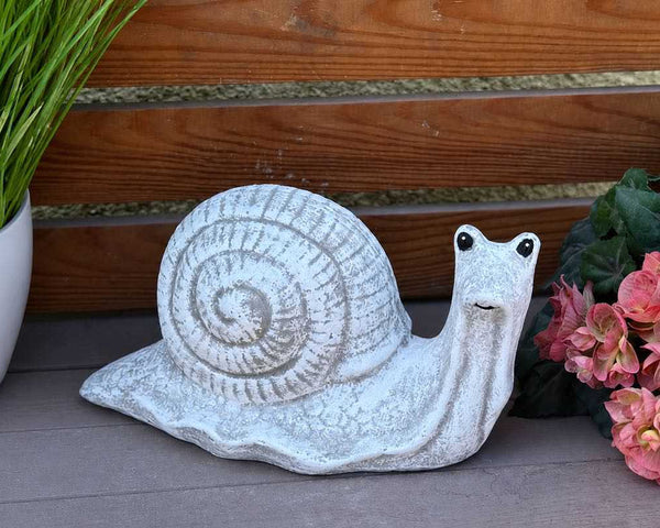 Detailreiche Schneckenfigur aus Steinguss mit freundlich gestaltetem Gesicht für den Garten