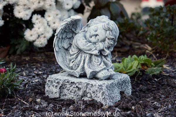 Steinfigur Engel auf Fels sitzend